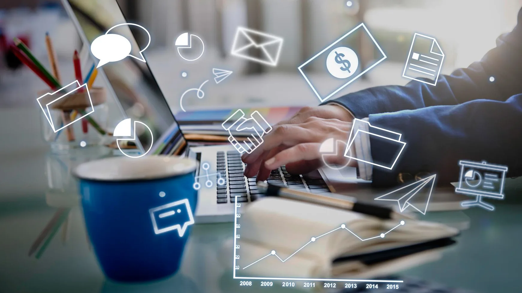 Hands typing on a tablet surrounded by marketing icons